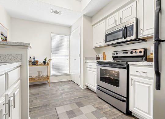 a renovated kitchen with white cabinets and stainless steel appliances