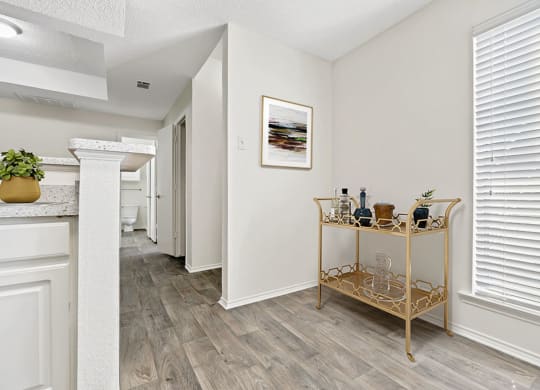 the living room and dining room of a home with white walls and wood floors