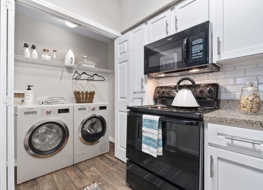 a laundry room with a washer and dryer and a white washer at Fountains of Denton in Denton, TX