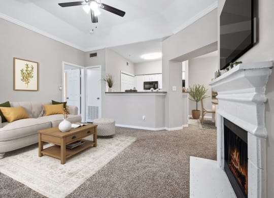 a living room with a fireplace and a couch at Fountains of Denton in Denton, TX