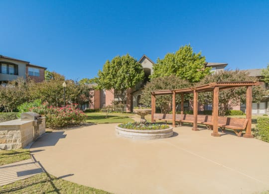 a patio with a bench and a fire pit at Fountains of Denton in Denton, TX