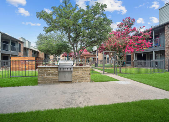 an outdoor barbecue area at legacy apartments in plano, tx