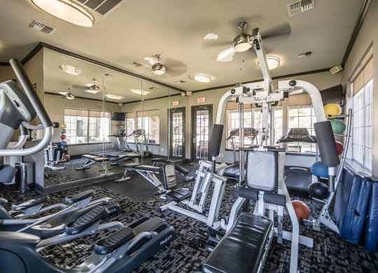 Exclusive Fitness Center with cardio machine and free weights at Fountains of Denton Apartments in Denton, TX