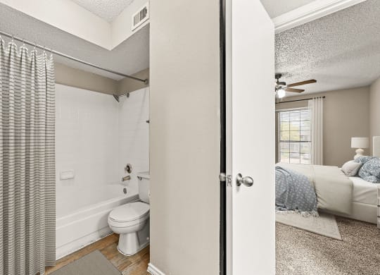 an open bathroom with a bed and a toilet in a bedroom