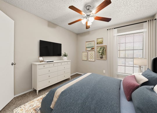 a bedroom with a bed and a ceiling fan