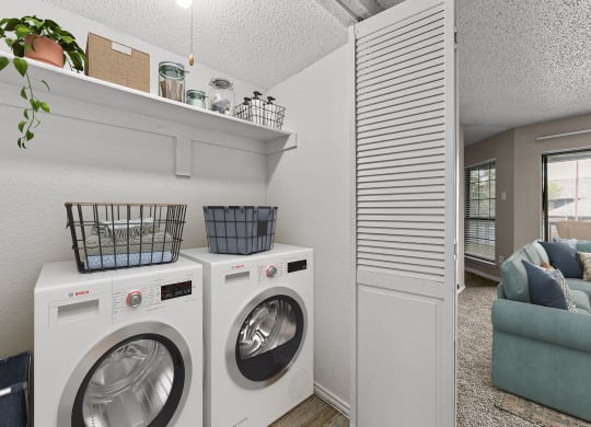 a washer and dryer in a laundry room with a couch