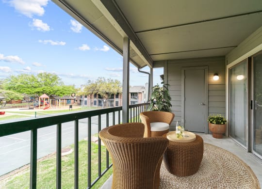 a patio with two chairs and a table on a balcony