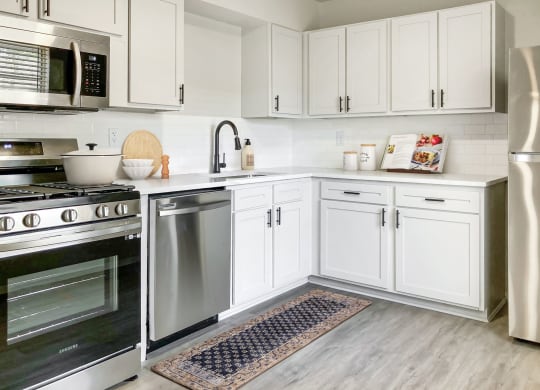 a kitchen with white cabinets and steel appliances at Sunset Heights, San Antonio