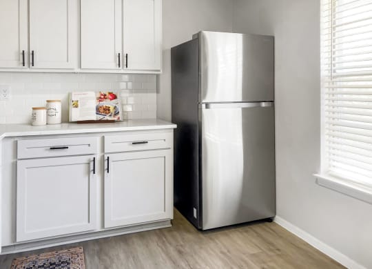 a kitchen with white cabinets and a stainless steel refrigerator  at Sunset Heights, Texas, 78209