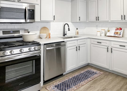 a kitchen with white cabinets and stainless steel appliances  at Sunset Heights, Texas