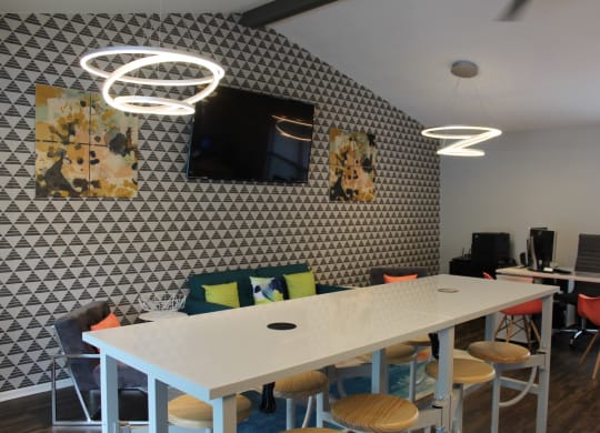 a room with a white table and chairs with colourful cushions on the back of the chairs