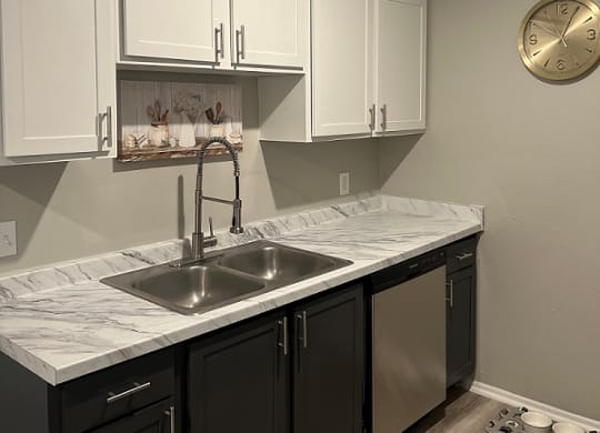 a kitchen with white cabinets and a clock on the wall