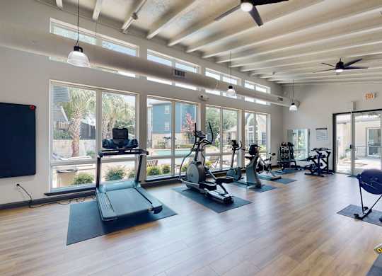 a gym with cardio equipment and windows  at Remington Ranch, Texas, 78247