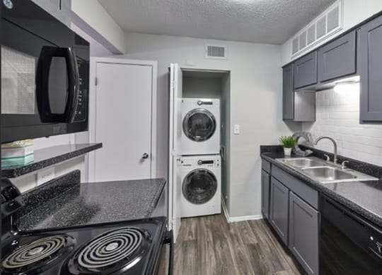 a kitchen with a washer and dryer and a sink