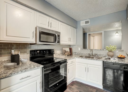 a kitchen with black appliances and white cabinets