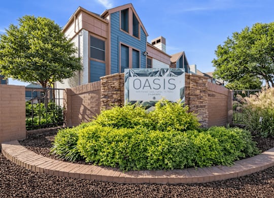 A sign that says Oasis in front of a building.