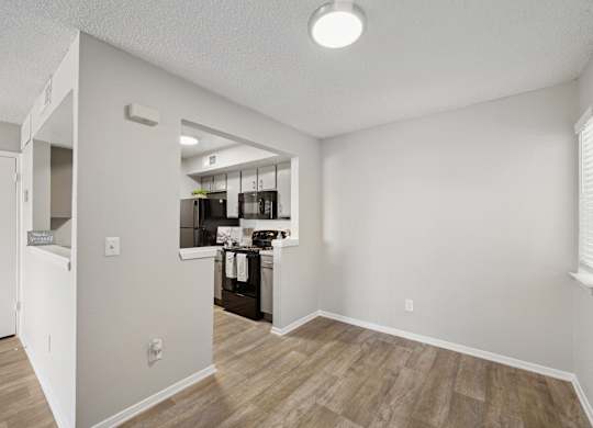 A kitchen area with a refrigerator, sink, and cabinets.