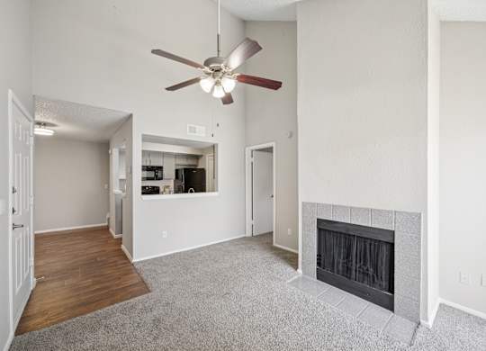A living room with a fireplace and a ceiling fan.