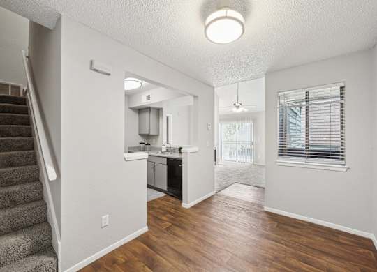 A kitchen area with a staircase on the left side.