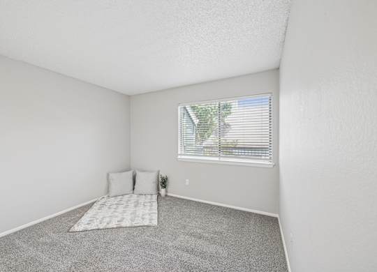 A bedroom with a window and a bed.