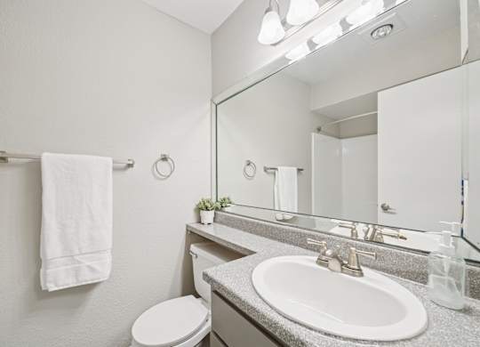 A white towel hangs on a towel rack in a bathroom.