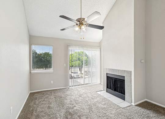 A room with a fireplace and a ceiling fan.