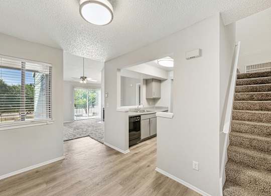 A spacious living room with a staircase leading to the upper floor.