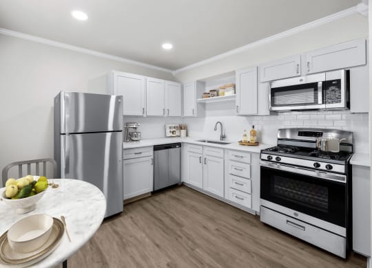 a kitchen with white cabinetry and stainless steel appliances  at Sunset Heights, San Antonio, Texas