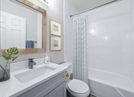 a bathroom with a white sink and toilet next to a white bathtub with a shower curtain  at Sunset Heights, Texas