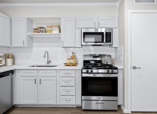 a kitchen with white cabinets and stainless steel appliances  at Sunset Heights, San Antonio