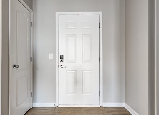 A white door with a black handle and lock in a room.