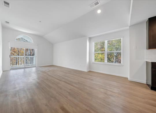an empty living room with white walls and a sliding glass door at The Vinings Apartments, Virginia, 23234