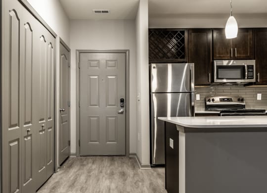 a kitchen with stainless steel appliances and a grey door Fisher, Indiana