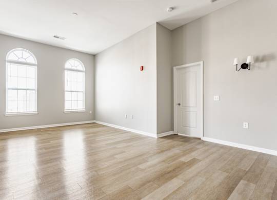 A room with wooden flooring and a white door.
