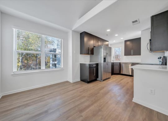 a kitchen and living room with a large window at The Vinings Apartments, Richmond