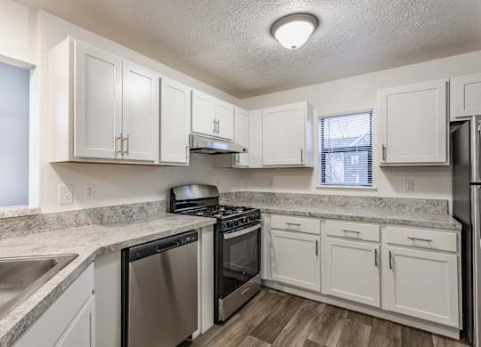 A kitchen with white cabinets and stainless steel appliances at Huntington Cove Apartments, Merrillville, IN, 46410