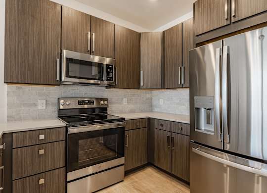 A modern kitchen with a stainless steel refrigerator and wooden cabinets at Upper Vue Flats, Dublin