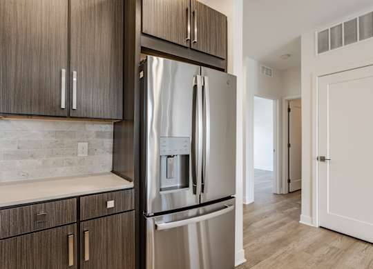 A modern kitchen with a stainless steel refrigerator and wooden cabinets at Upper Vue Flats, Dublin