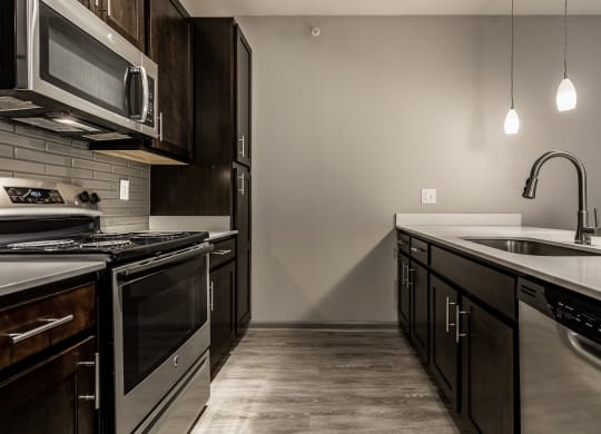 an empty kitchen with stainless steel appliances and a sink at Bella Vista Apartments, Fishers