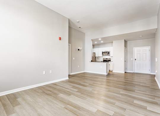 A room with wooden flooring and white walls.