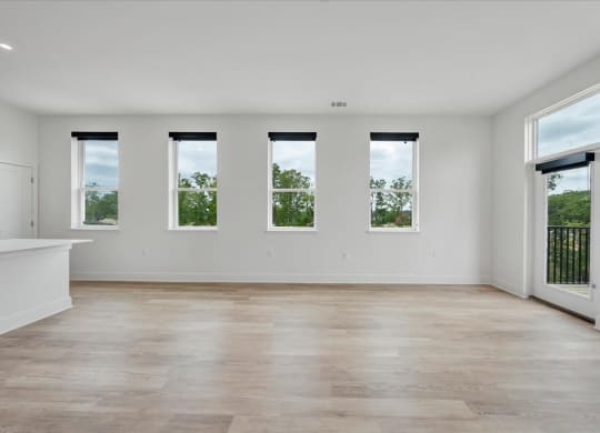 an empty living room with white walls and wood floors at Luxe 360 in Midlothian, Virginia, 23114
