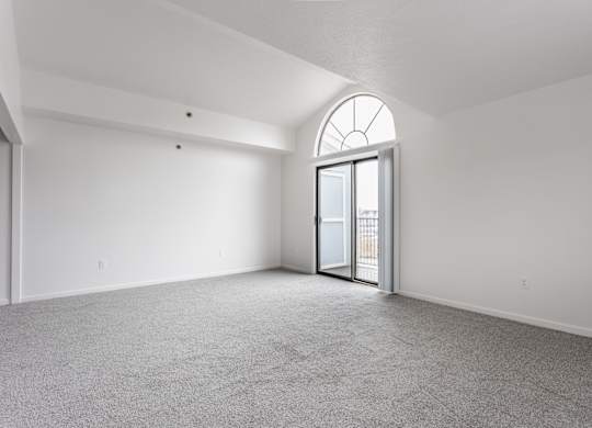 A room with a carpeted floor and a large arched window at Huntington Cove Apartments, Merrillville, IN, 46410