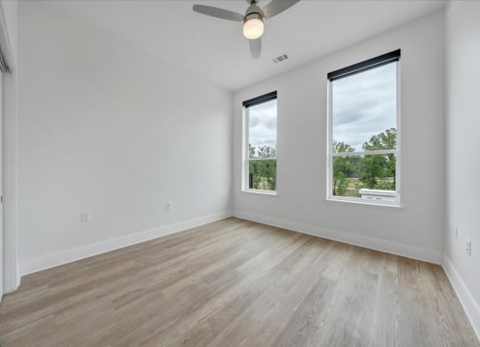 an empty room with three windows and a ceiling fan at Luxe 360 in Midlothian, Midlothian
