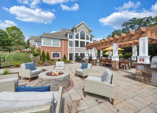 a backyard patio with chairs and a fire pit at Sunscape Apartments, Virginia