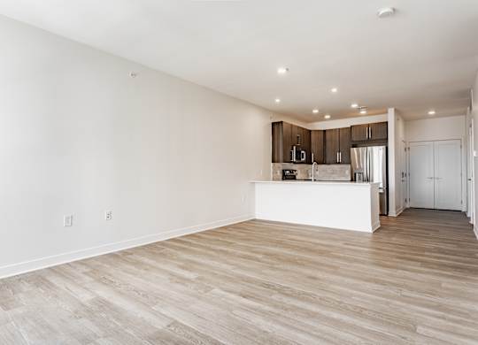 A spacious room with wooden flooring and a kitchen area in the background at Upper Vue Flats, Dublin