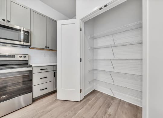a kitchen with white cabinets and a large white closet