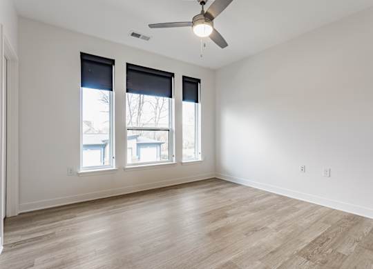 A room with a ceiling fan and three windows at Upper Vue Flats, Dublin