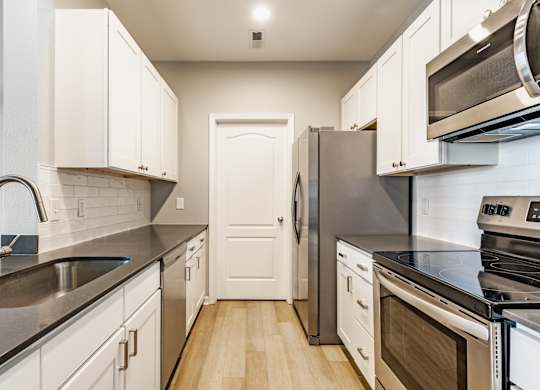 A kitchen with white cabinets and stainless steel appliances.