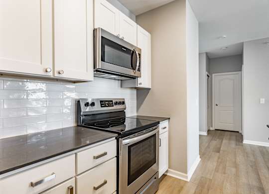 A kitchen with a stove top oven and microwave above it.
