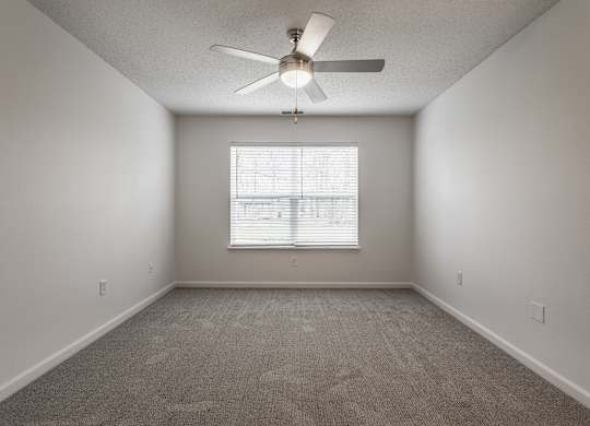 an empty room with a ceiling fan and a window at Latitudes Apartments, Indianapolis, Indiana